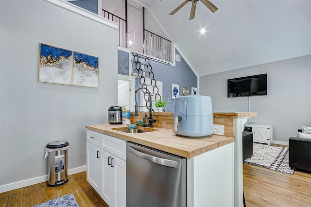 1079 Johnson Rd, Gilchrist, TX 77617 - kitchen with wooden counters, stainless steel dishwasher, light wood finished floors, baseboards, and vaulted ceiling