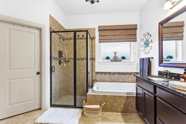 bathroom featuring a stall shower, tile patterned flooring, vanity, and a garden tub