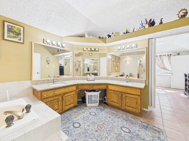 13523 Pasa Robles Ln, Houston, TX 77083 - full bathroom featuring tile patterned flooring, a sink, a garden tub, and a textured ceiling