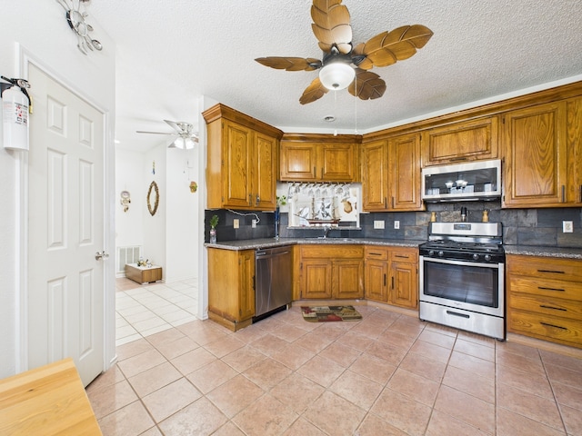 13523 Pasa Robles Ln, Houston, TX 77083 - kitchen with a sink, brown cabinets, stainless steel appliances, and a ceiling fan
