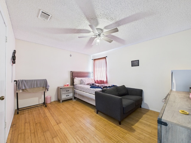 13523 Pasa Robles Ln, Houston, TX 77083 - bedroom featuring a textured ceiling, light wood-style floors, ceiling fan, and visible vents