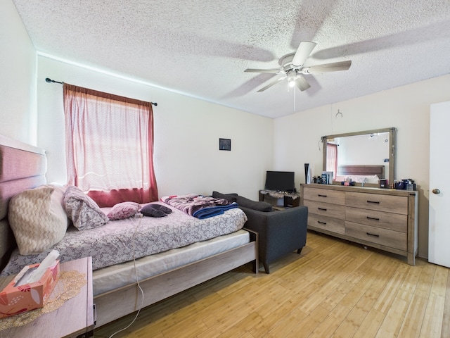13523 Pasa Robles Ln, Houston, TX 77083 - bedroom with multiple windows, light wood-style floors, ceiling fan, and a textured ceiling