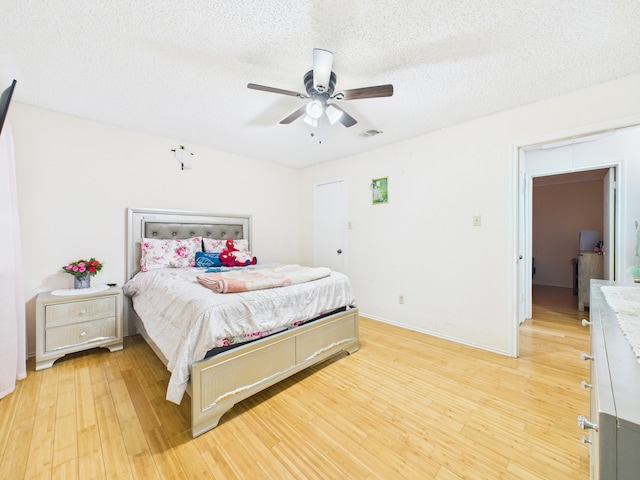 13523 Pasa Robles Ln, Houston, TX 77083 - bedroom with a textured ceiling, visible vents, baseboards, ceiling fan, and light wood-type flooring