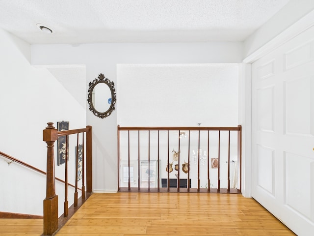 13523 Pasa Robles Ln, Houston, TX 77083 - hall with an upstairs landing, a textured ceiling, and light wood-style floors