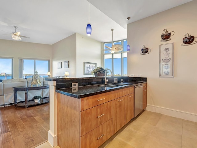 kitchen with open floor plan, a peninsula, a sink, and a ceiling fan