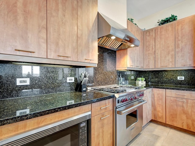 kitchen with tasteful backsplash, premium range, dark stone countertops, wall chimney range hood, and black microwave