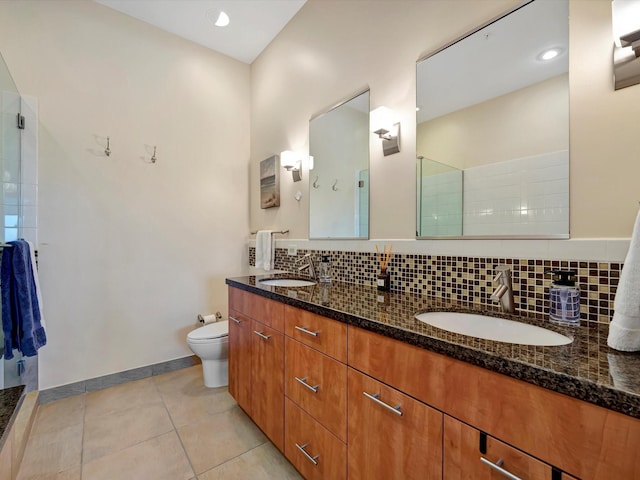 full bath with backsplash, toilet, a sink, and a walk in shower
