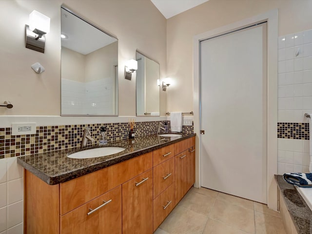 bathroom with double vanity, a sink, tile patterned floors, and tasteful backsplash