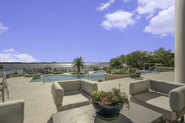 pool with outdoor lounge area, a water view, and a patio area