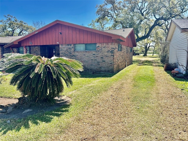 325 Hargett St, Clute, TX 77531 - view of property exterior with brick siding, board and batten siding, and a yard