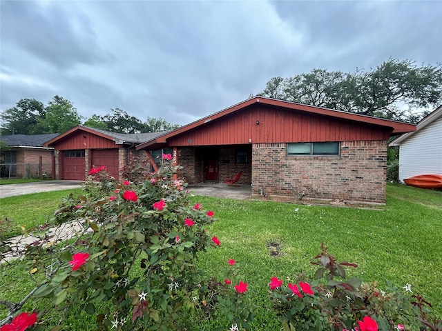 325 Hargett St, Clute, TX 77531 - view of front of home featuring brick siding, a front yard, an attached garage, and concrete driveway