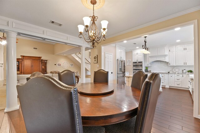 2536 22nd Ave N, Texas City, TX 77590 - dining space with visible vents, crown molding, ornate columns, stairs, and dark wood-style floors
