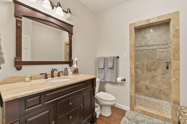 2536 22nd Ave N, Texas City, TX 77590 - bathroom featuring vanity, toilet, baseboards, tiled shower, and wood finished floors