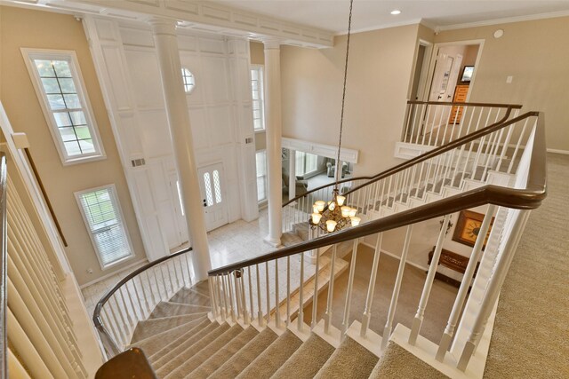 2536 22nd Ave N, Texas City, TX 77590 - stairs featuring a notable chandelier, carpet flooring, a high ceiling, ornamental molding, and ornate columns