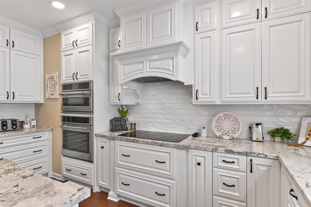 2536 22nd Ave N, Texas City, TX 77590 - kitchen with black electric stovetop, double oven, white cabinets, and tasteful backsplash