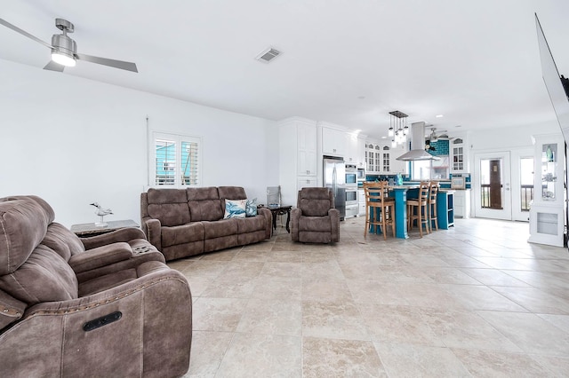 living room featuring light tile patterned floors, ceiling fan, and visible vents