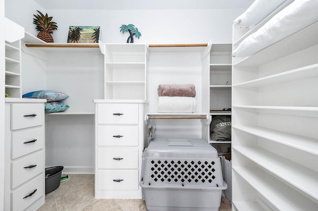 walk in closet with light tile patterned floors