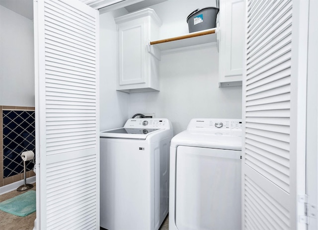 laundry room with independent washer and dryer, cabinet space, and tile walls