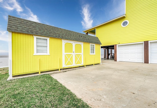 view of shed featuring a garage and concrete driveway