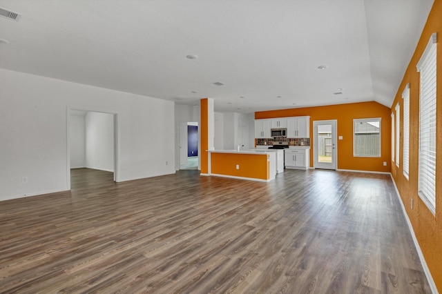 3148 Catalonion Ct, Conroe, TX 77301 - unfurnished living room with dark wood-type flooring, lofted ceiling, and baseboards