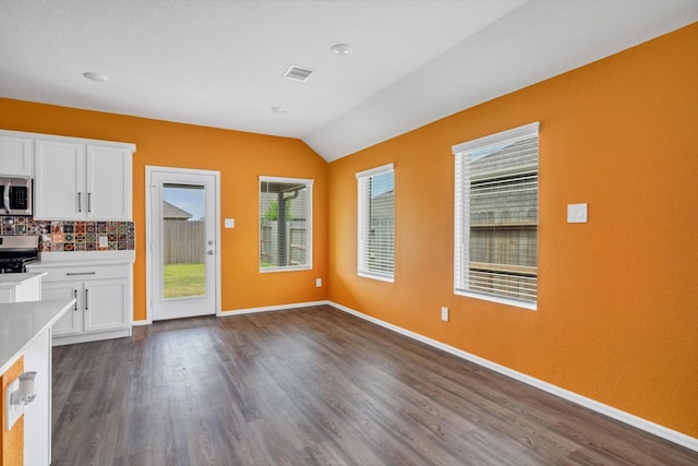 3148 Catalonion Ct, Conroe, TX 77301 - unfurnished living room featuring vaulted ceiling, dark wood finished floors, and baseboards