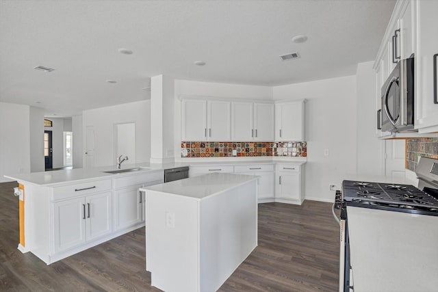 3148 Catalonion Ct, Conroe, TX 77301 - kitchen featuring stainless steel appliances, a sink, dark wood-style flooring, a peninsula, and decorative backsplash