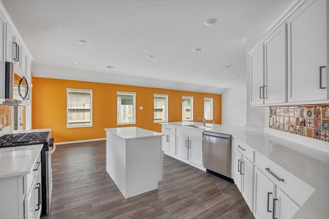 3148 Catalonion Ct, Conroe, TX 77301 - kitchen with stainless steel appliances, a peninsula, a sink, backsplash, and dark wood finished floors
