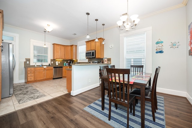 3529 Avenue S, Galveston, TX 77550 - dining space featuring baseboards, light wood-style floors, ornamental molding, and an inviting chandelier