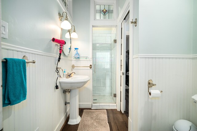 3529 Avenue S, Galveston, TX 77550 - bathroom with wood finished floors, toilet, a sink, a stall shower, and wainscoting