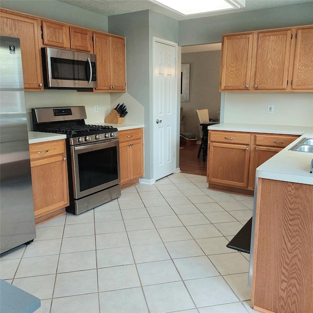18146 River Sage Dr, Houston, TX 77084 - kitchen with stainless steel appliances, light countertops, and light tile patterned flooring
