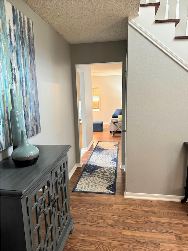 18146 River Sage Dr, Houston, TX 77084 - corridor featuring wood finished floors, baseboards, a textured ceiling, and stairway
