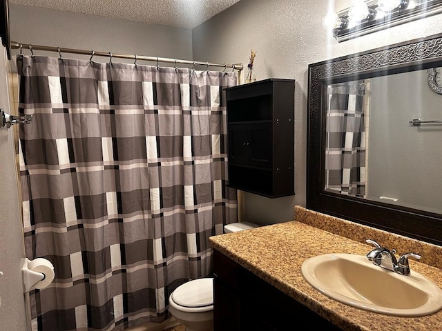 full bathroom featuring a shower with curtain, vanity, toilet, a textured wall, and a textured ceiling