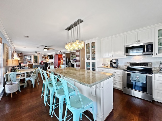 kitchen featuring ceiling fan with notable chandelier, white cabinetry, appliances with stainless steel finishes, and dark wood-style flooring