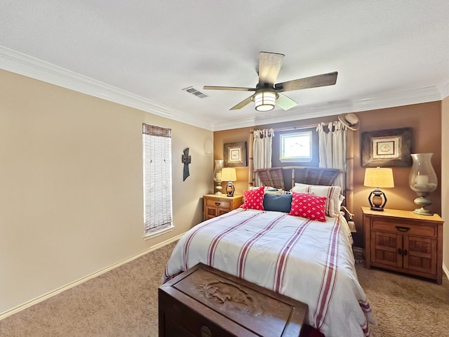 carpeted bedroom featuring baseboards, ornamental molding, visible vents, and a ceiling fan