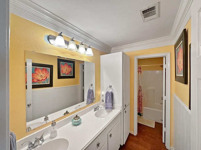 bathroom featuring a sink, crown molding, and visible vents