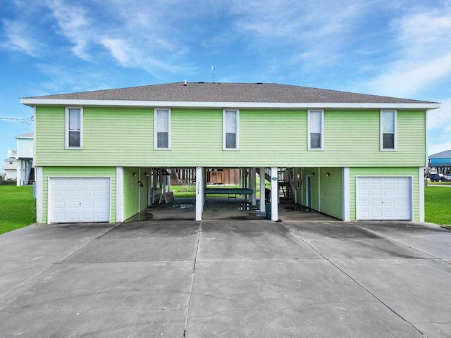 view of front facade featuring driveway, a carport, and a garage