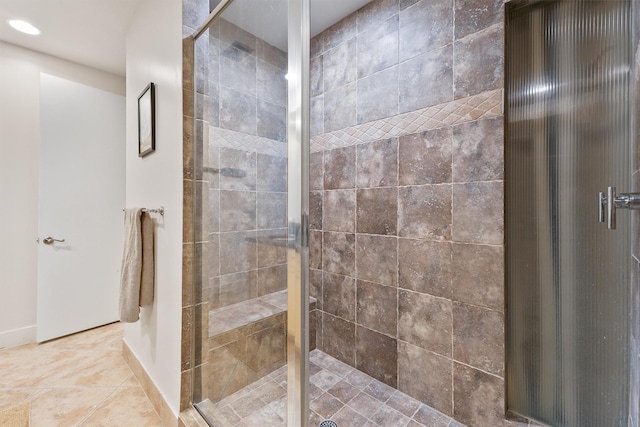 full bath featuring baseboards, a stall shower, and tile patterned flooring