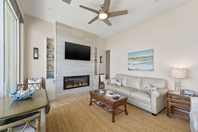 living area with a ceiling fan, light tile patterned floors, built in features, and a fireplace