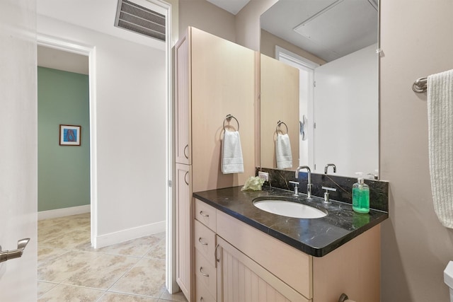 bathroom featuring baseboards, visible vents, tile patterned floors, and vanity