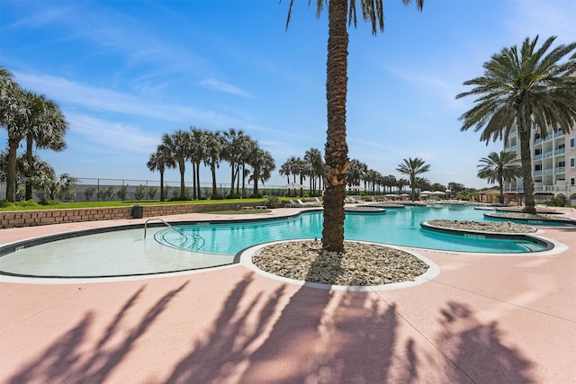 pool with a patio and fence