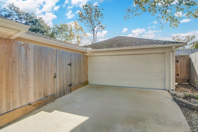 garage featuring fence and driveway
