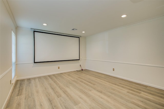 home theater with baseboards, wood finished floors, visible vents, and ornamental molding
