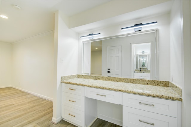 bathroom with baseboards, recessed lighting, wood finished floors, vanity, and ornamental molding