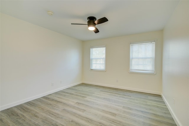 empty room featuring light wood-type flooring, baseboards, and ceiling fan