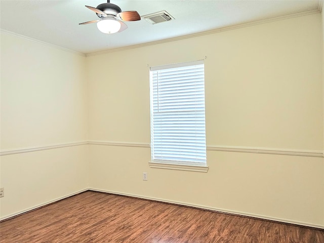 spare room featuring crown molding, a ceiling fan, wood finished floors, and visible vents