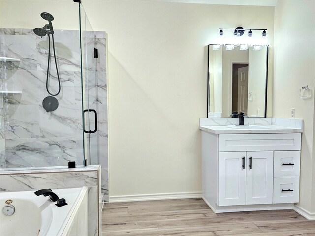 full bathroom with a bath, a marble finish shower, baseboards, wood finished floors, and vanity