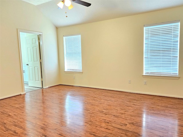 unfurnished room featuring baseboards, a ceiling fan, wood finished floors, and vaulted ceiling