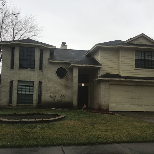 view of front facade with a front lawn, a chimney, an attached garage, and brick siding