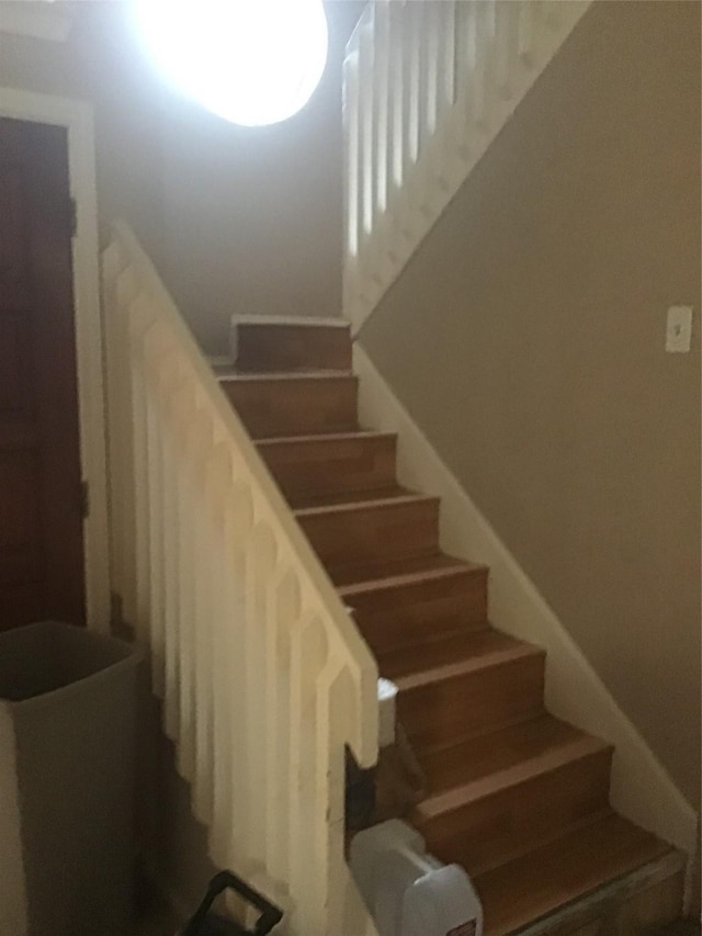 stairway featuring baseboards and wood finished floors