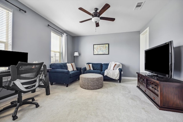 home office featuring baseboards, visible vents, a ceiling fan, and light carpet
